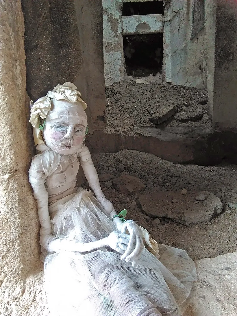 Human woman sculpture at the entrance of a derelict cave.