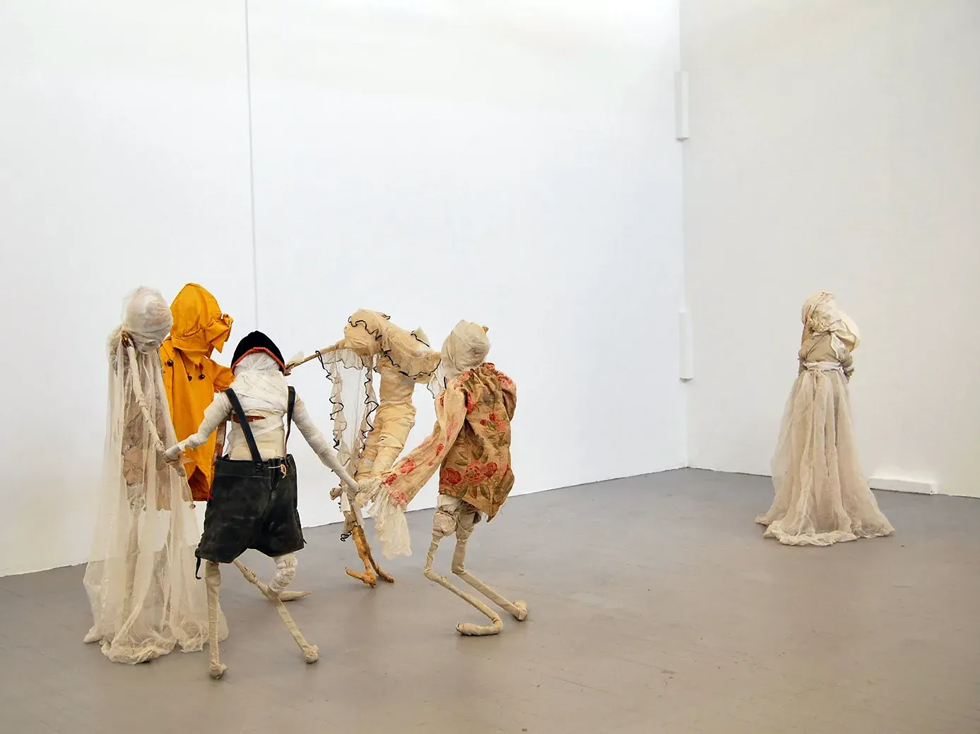 Five boy sculptures holding hands and dancing in a circle. A girl sculpture standing offside.