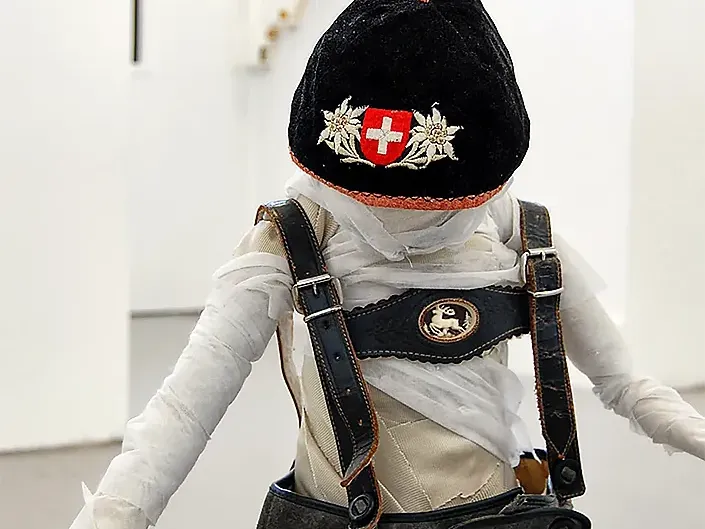 One boy with a wool hat decorated with edelweiss and swiss coat of arms.