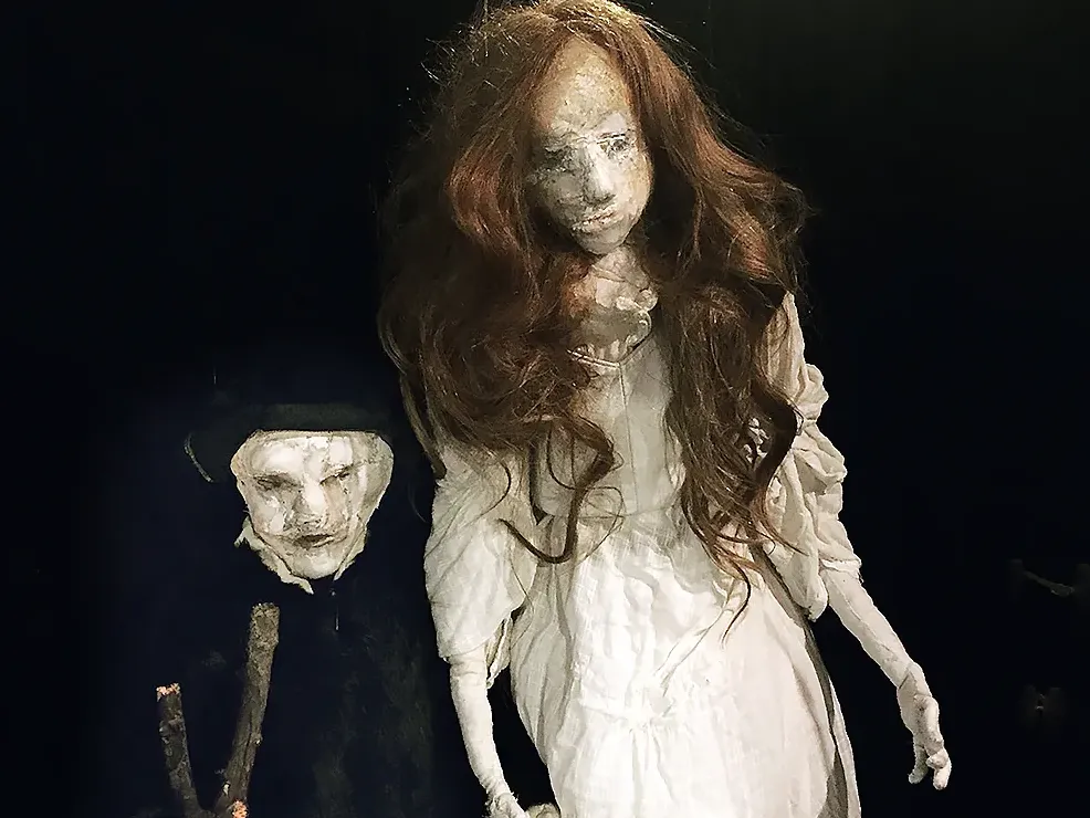 Girl and smaller boy in dark surrounding.