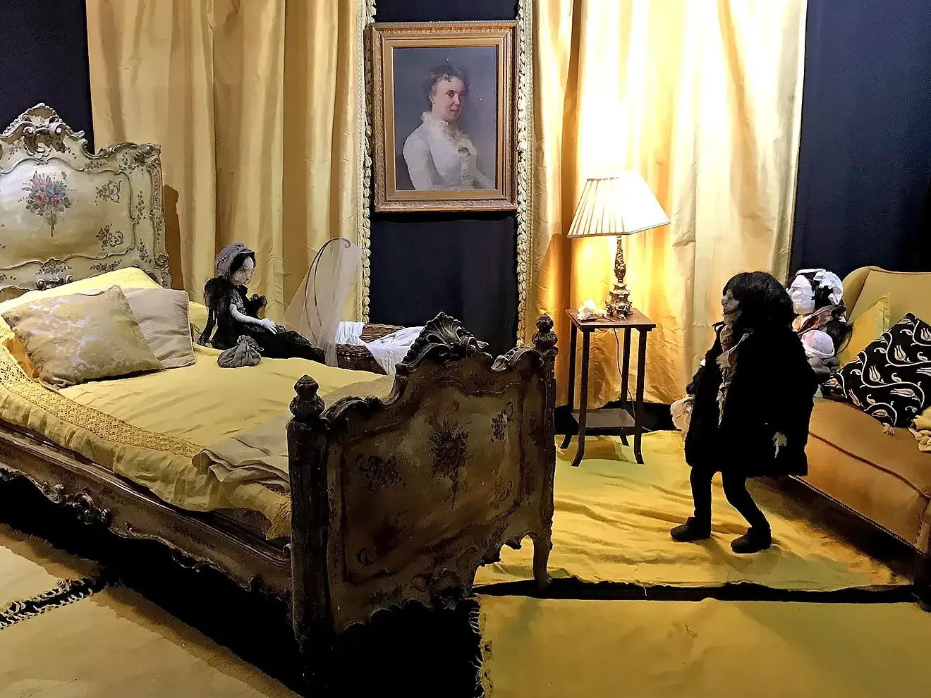 Central view into a bedroom with dominant yellow colour design with four human-like sculptures.