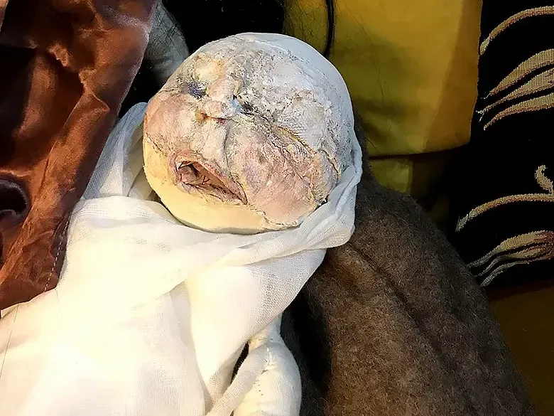 Baby figure in a woman's arm.
