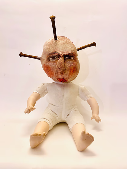 Porcelain doll with uncanny soft head and big rusty nails inserted